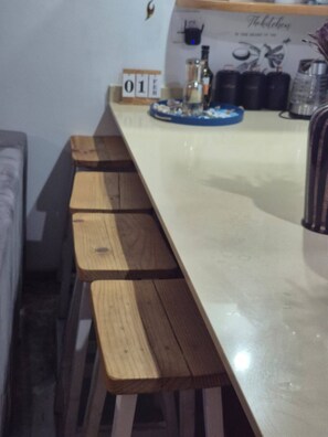 A long wooden table with benches, a small clock, and a decorative item on the wall. - Luxurious Beach Apartment (Westbrook)