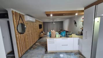A modern kitchen with a wooden accent wall, a built-in oven, and a countertop with various items.