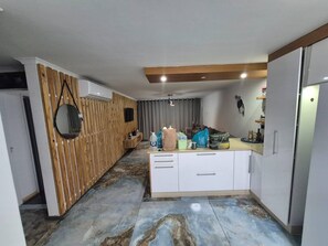 A modern kitchen with a wooden accent wall, a built-in oven, and a countertop with various items.