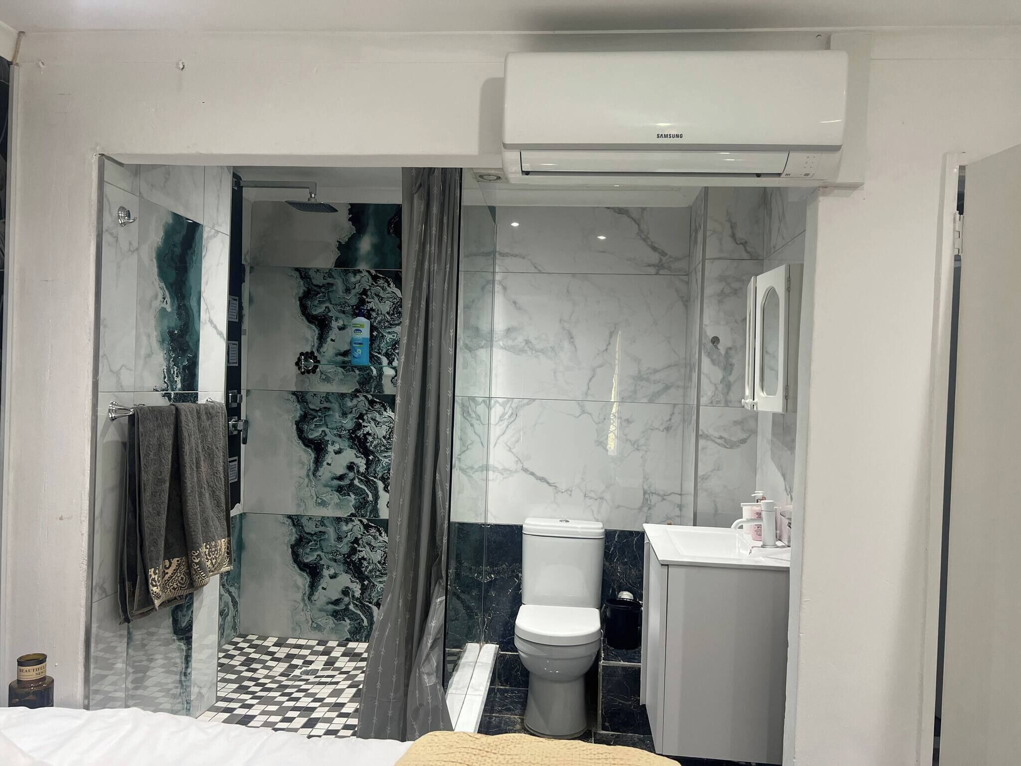 A modern bathroom with a shower, toilet, and sink.