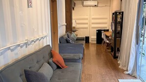 Ein kompakter Wohnbereich mit einer Couch, einem kleinen Tisch und einem Bücherregal.