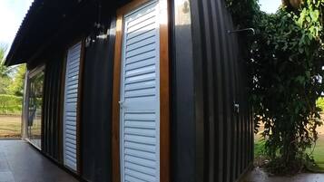 Um edifício com fachada preta, duas portas brancas e uma pequena janela.