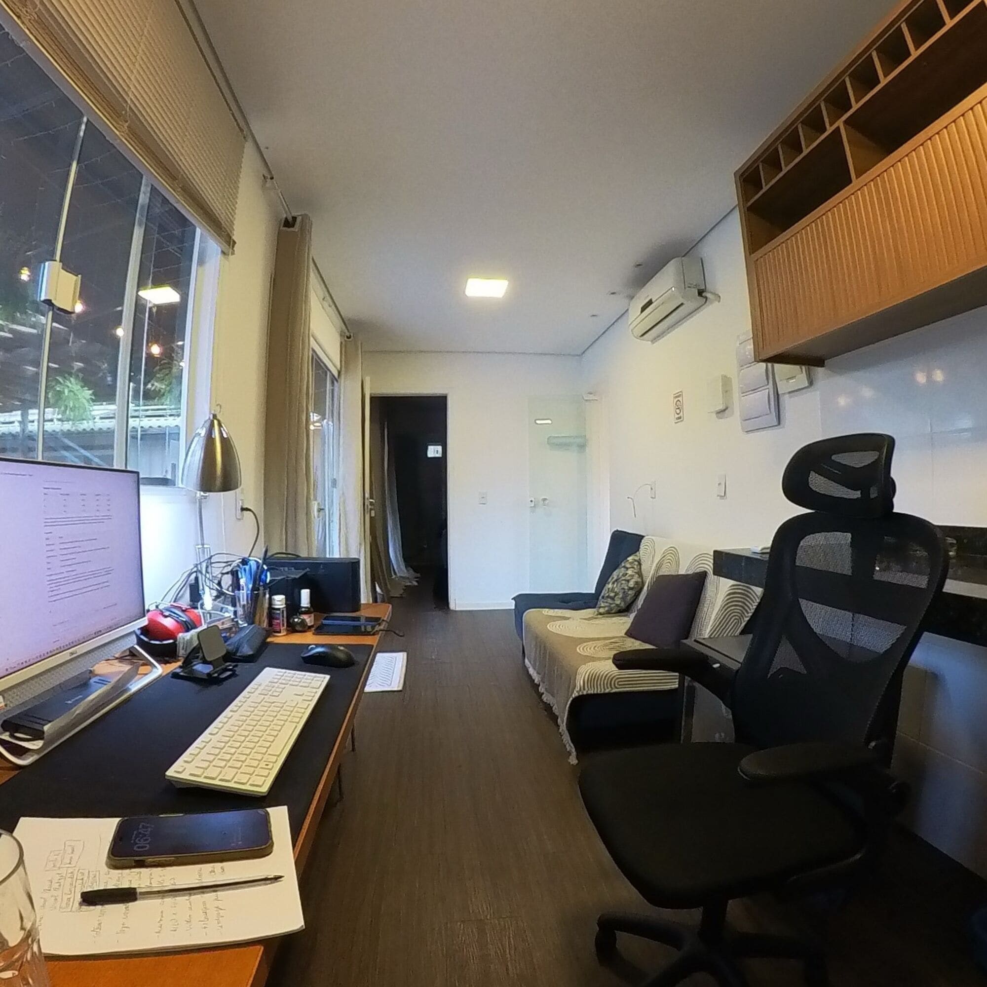 Quarto com escrivaninha, computador, cadeira e cama.