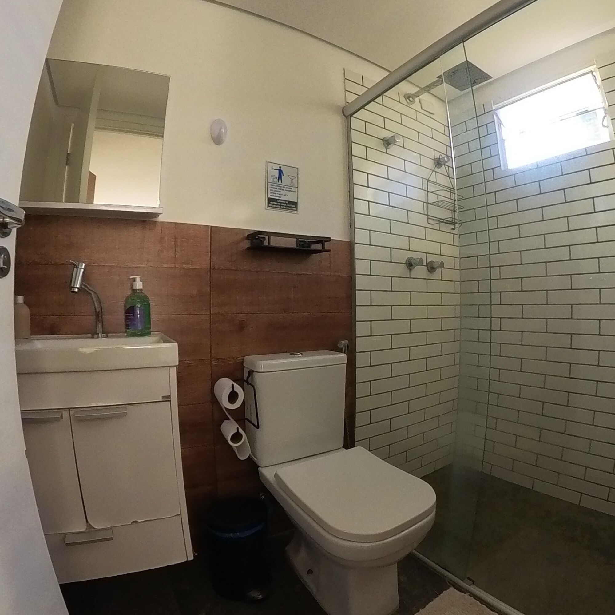 Un baño con inodoro, lavamanos y zona de ducha.