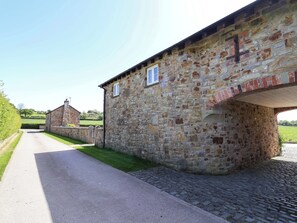 Ein Steinhaus mit einer gepflasterten Straße davor.