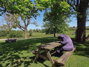 Ein Picknicktisch in einem Park mit einer Bärenstatue.