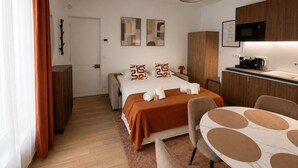 A modern hotel room with a bed, a desk, a chair, a microwave, and a coffee maker. - Exclusive Chic Stay! Live Next to the Eiffel Tower (Paris)