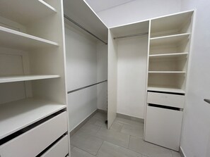 A walk-in closet with multiple shelves and hanging space, a metal rod for hanging items, and a tiled floor. - 2 bed Villa in Hastings, Walking distance to Amenities - NO CAR NEEDED (Bridgetown)