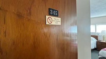 Porta de quarto de hotel com placa de proibido fumar e o número 345.