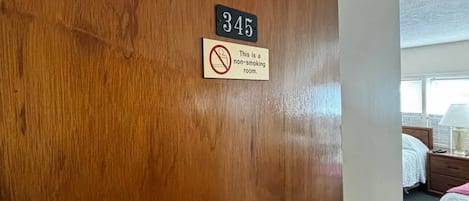 Une porte de chambre d’hôtel avec un panneau indiquant « interdiction de fumer » et le numéro de chambre : 345.