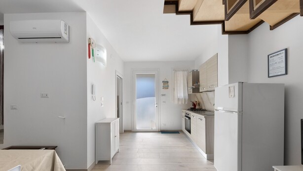 A modern kitchen with white cabinets, a built-in oven, and a refrigerator. - Apartment 'La Putea Salento' with Private Terrace, Wi-Fi and Air Conditioning (Corsano)