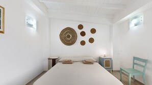 A bedroom with a bed, a nightstand, a chair, and wall decor. - Apartment 'La Putea Salento' with Private Terrace, Wi-Fi and Air Conditioning (Corsano)