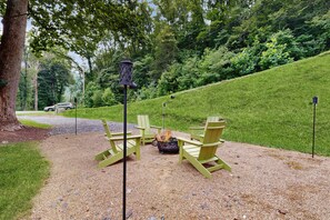 An outdoor seating area with a table and chairs, surrounded by gravel and greenery. - Riverfront Wilderness Cabin (Cullowhee)