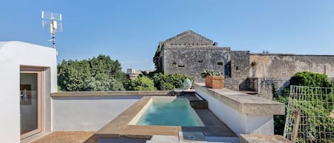 A rooftop pool area with a view of a historic building in the background.