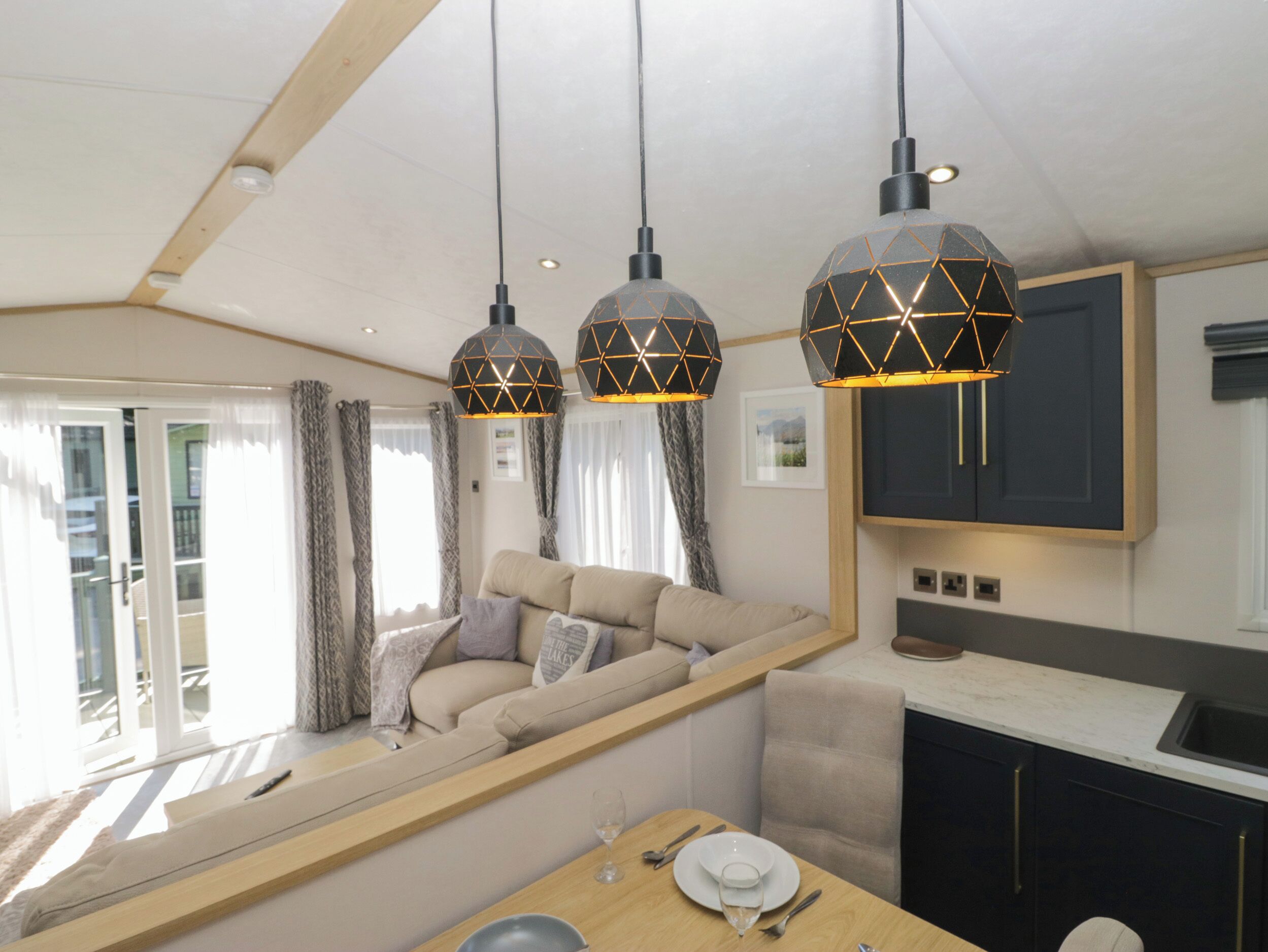 A modern interior with a sofa, dining table, and pendant lights.