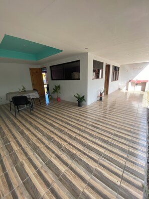 A spacious room with a tiled floor, a dining table with chairs, and a potted plant. - Vrbo Property (Provincia de Guanacaste)