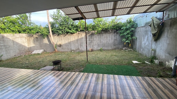 A covered patio area with a tiled floor, a small table, and a green mat. - Vrbo Property (Provincia de Guanacaste)