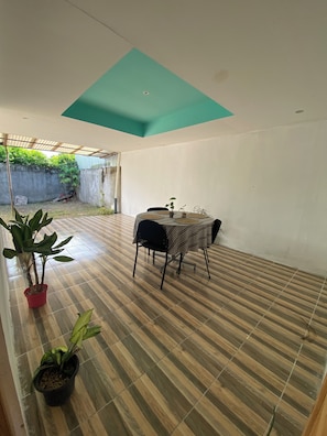 A room with a tiled floor, a table with chairs, and potted plants. - Vrbo Property (Provincia de Guanacaste)