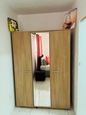 A room with a wooden wardrobe, a bed with pillows, and a mirror. - Vibra Lux Island Escape Cozy 1BR Near Beaches & Philipsburg (Philipsburg)