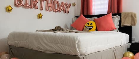 A bedroom with a bed, pillows, and a ceiling fan.