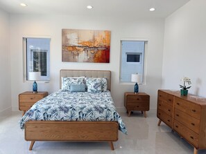 A bedroom with a bed, nightstands, a dresser, and artwork on the walls. - #3 2-bedroom condo in tranquil Savannah with cool AC breeze (Savannah)