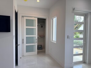A hallway with a closet, a door leading outside, and a window with a view of greenery. - #3 2-bedroom condo in tranquil Savannah with cool AC breeze (Savannah)