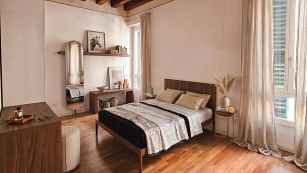 A bedroom with a wooden bed, bedside tables, a mirror, and a window with curtains. - ApartmentsArena - Capitolium Verona 5 (Verona)
