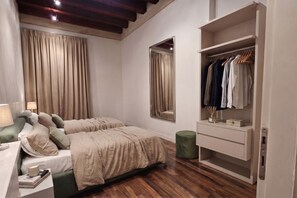A bedroom with a bed, bedside table, lamp, wardrobe, and a mirror. - ApartmentsArena - Capitolium Verona 5 (Verona)