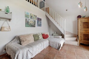 A living room with a sofa, a staircase, and a cabinet.