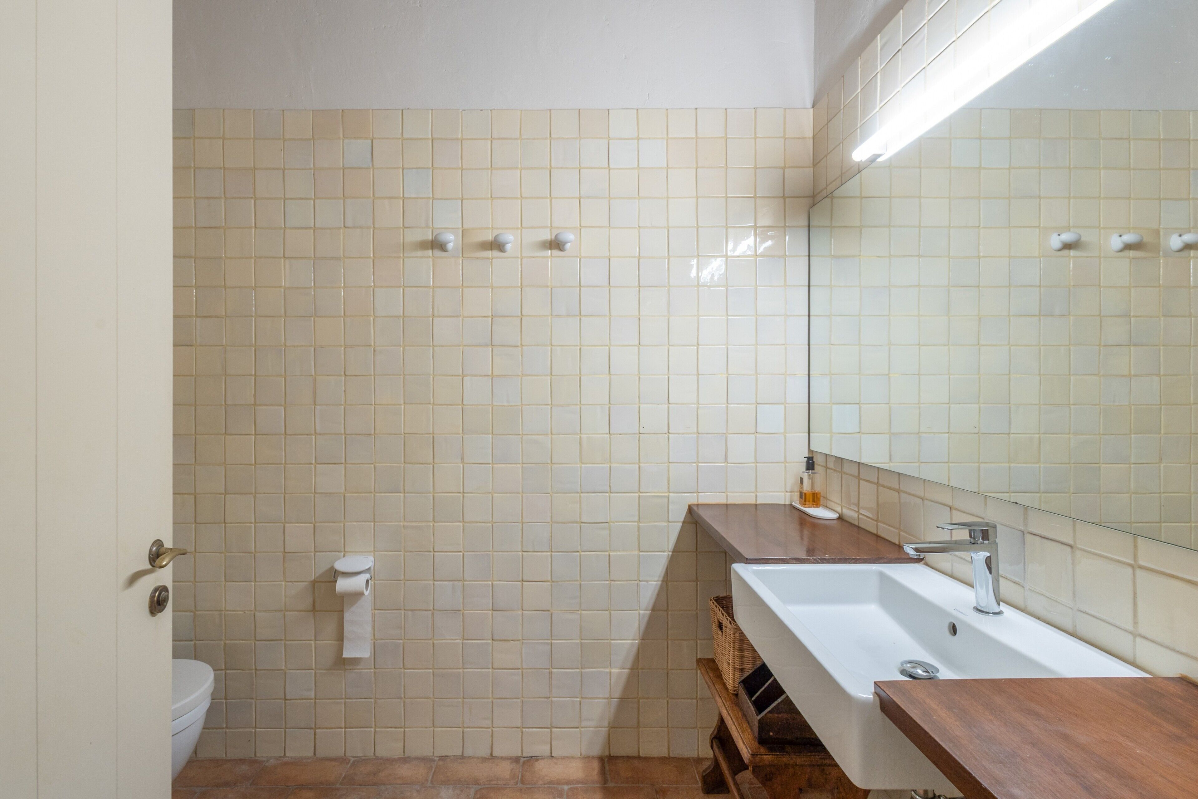 Un baño con inodoro, lavamanos y espejo.