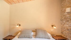 Una camera da letto con un letto singolo, due comodini e due lampade a parete.