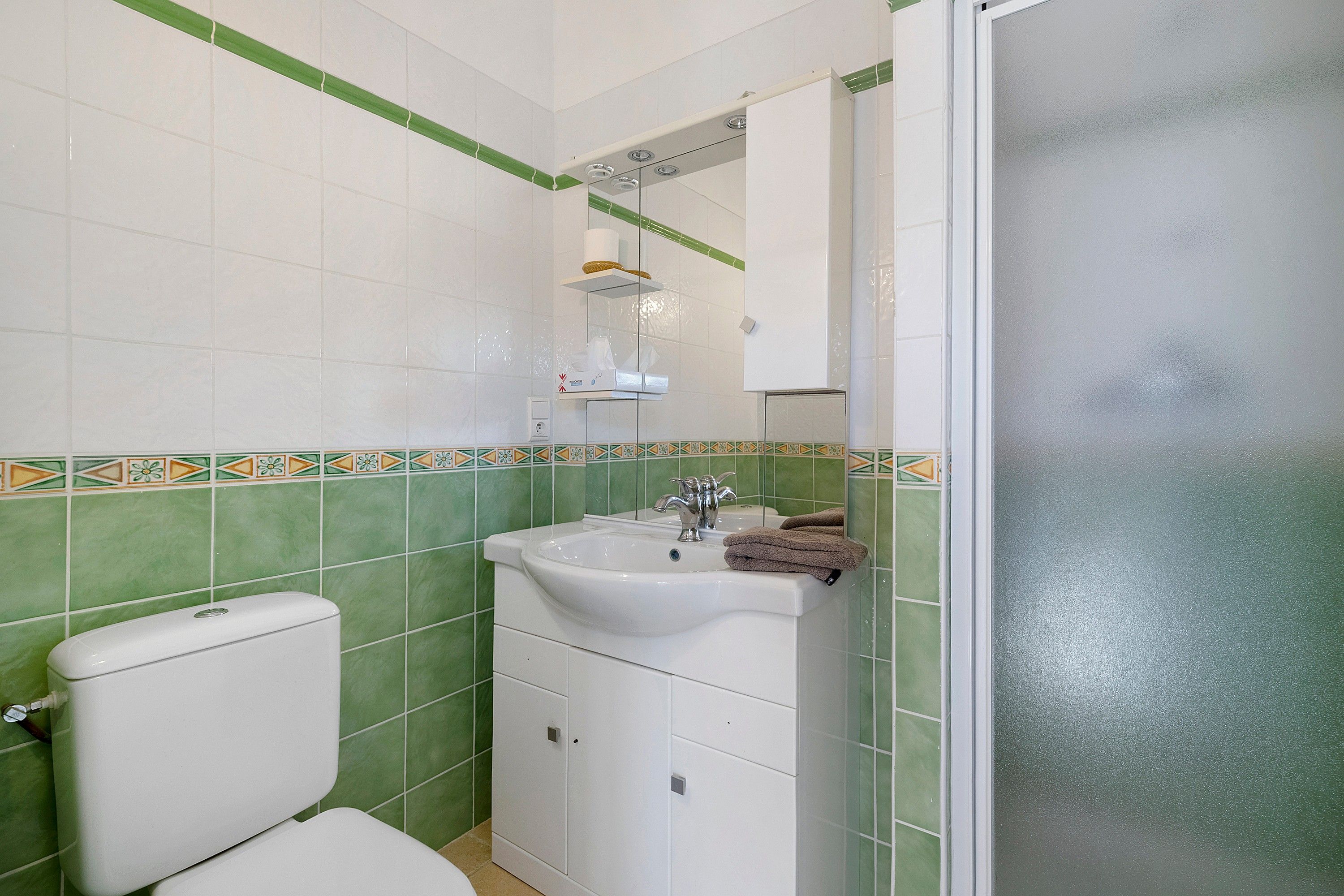 Une salle de bain avec des toilettes, un lavabo et un miroir.