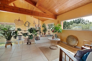A spacious room with a high ceiling, wooden beams, large windows, and various potted plants. - House with Private Pool, Terraces, Wi-Fi, and View in Sainte-Camelle (Sainte-Camelle)