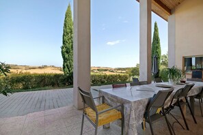An outdoor patio with a table and chairs, overlooking a rural landscape with fields and trees. - House with Private Pool, Terraces, Wi-Fi, and View in Sainte-Camelle (Sainte-Camelle)