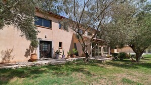 Una casa con un camino de piedra que lleva a la entrada, rodeada de césped y árboles.