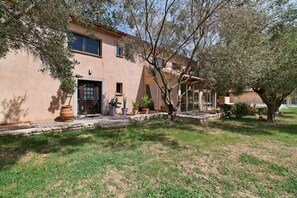 A house with a stone pathway leading to the entrance, surrounded by grass and trees. - House with Private Pool, Terraces, Wi-Fi, and View in Sainte-Camelle (Sainte-Camelle)