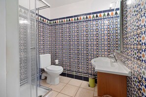 A bathroom with a tiled wall, a toilet, a sink, and a shower area. - House with Private Pool, Terraces, Wi-Fi, and View in Sainte-Camelle (Sainte-Camelle)