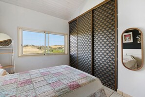 A bedroom with a bed, a window, a wardrobe, and a mirror. - House with Private Pool, Terraces, Wi-Fi, and View in Sainte-Camelle (Sainte-Camelle)