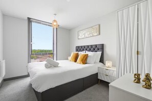 A bedroom with a bed, bedside table, and a nightstand. - Apartment Sleeps 4 - Air Con, City Centre, Wifi (Birmingham)