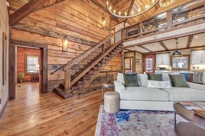 Ein geräumiger Wohnbereich mit Treppe, Holzwänden und einer modernen Küche.