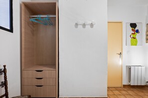A room with a wooden wardrobe, a radiator, and a door with a painting. - Chez Géraldine Apartment (Sainte-Croix-du-Verdon)