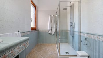 Un bagno con doccia, WC e lavandino.