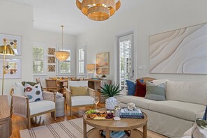 Ein helles Wohnzimmer mit Essbereich, ausgestattet mit einer Kandelaber, einem Sofa und einem Couchtisch mit Snacks.