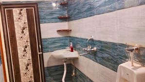 Une salle de bain comprenant un lavabo, un miroir, une douche et une porte ornée d’un panneau décoratif.