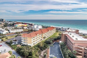 Ein Küstenhotel mit mehreren Gebäuden, einem Parkplatz und Meerblick.