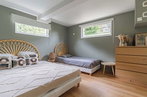 A bedroom with a bed, a chair, a dresser, and two windows. - Exceptional House With Pool 12P - Englesqueville (Englesqueville-en-Auge)