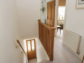 Una escalera con barandillas de madera que lleva a un rellano.