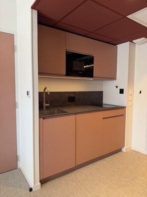 A compact kitchen with a built-in Bosch oven, a stainless steel sink, and a single countertop.