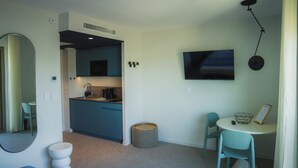 Un espace de vie compact comprenant une kitchenette, un coin repas et une salle de bain.