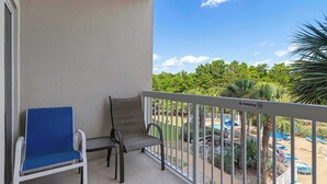 A balcony with two chairs, a view of a pool area, and a 'No Smoking' sign. - Coastal Comfort at TOPSL Summit 309C (Miramar Beach)